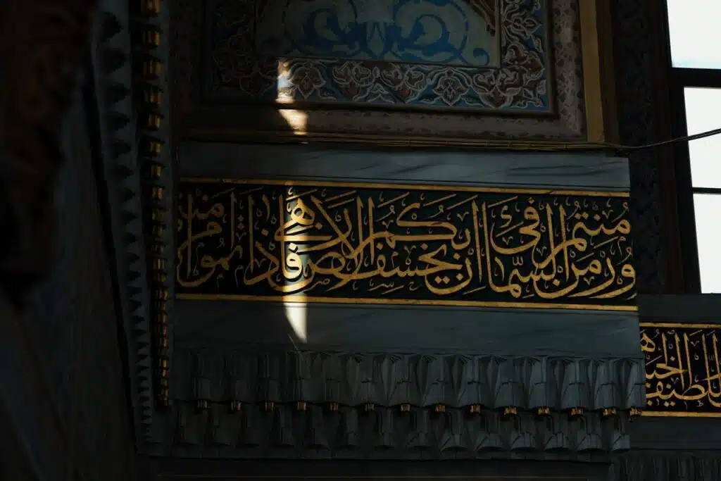 Intricate Arabic calligraphy adorns the ornate walls of an Istanbul mosque, highlighting Islamic artistry.