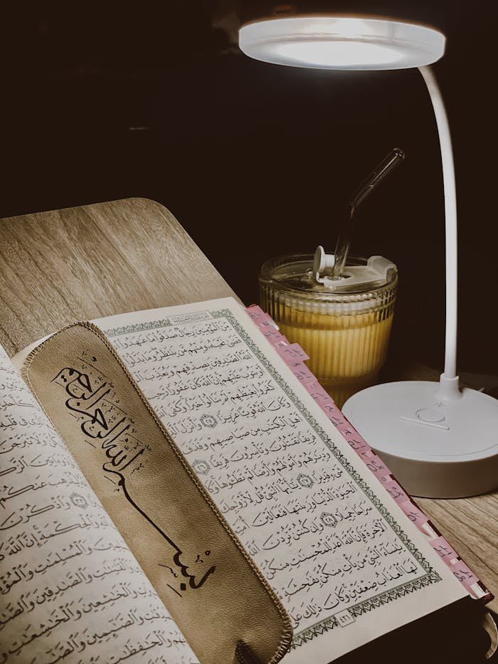 pexels photo 32166701 Open Quran with bookmark under a lamp, creating a serene reading ambiance.
