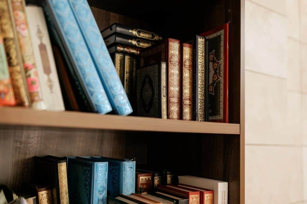 pexels photo 8164399 Close-up of decorative Islamic books on a wooden shelf, showcasing intricate bindings.